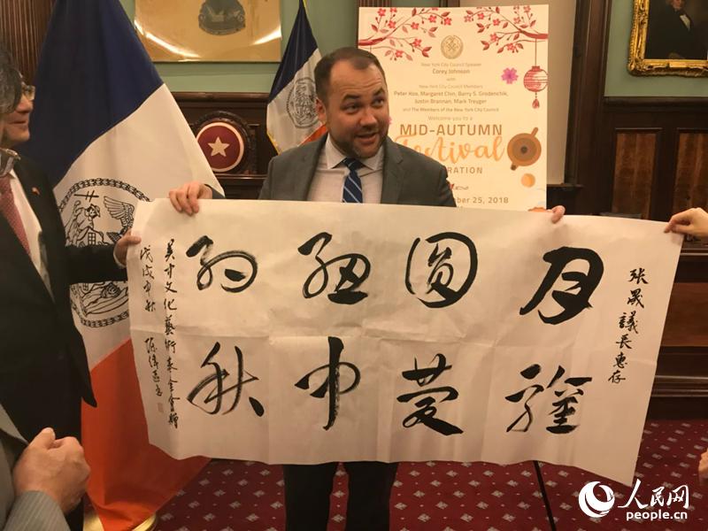 紐約市議會(huì)議長(zhǎng)約翰遜在“月圓紐約”歡度中秋活動(dòng)現(xiàn)場(chǎng)展示中國(guó)書(shū)法贈(zèng)品。 李曉宏攝