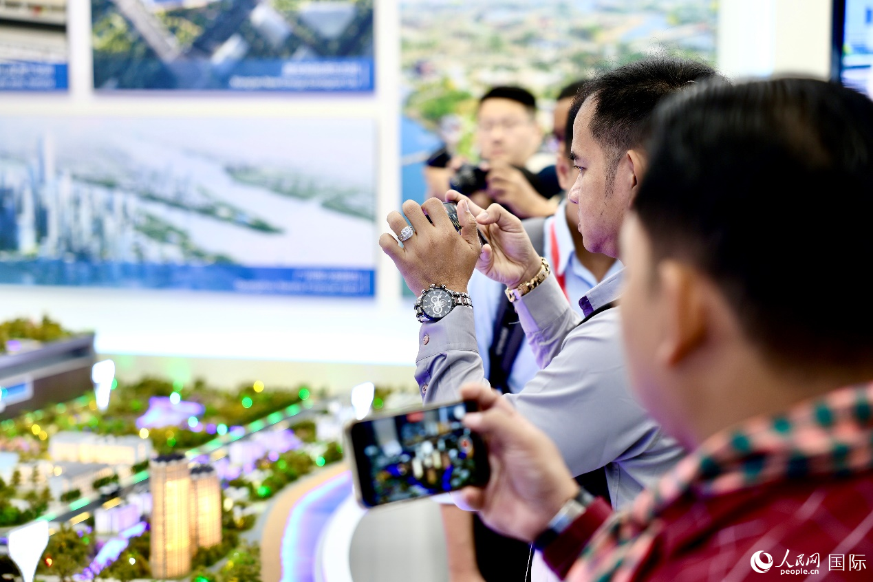 外媒記者在中國(guó)能建集團(tuán)展覽館仿真模型前拍照。人民網(wǎng) 李世奇攝