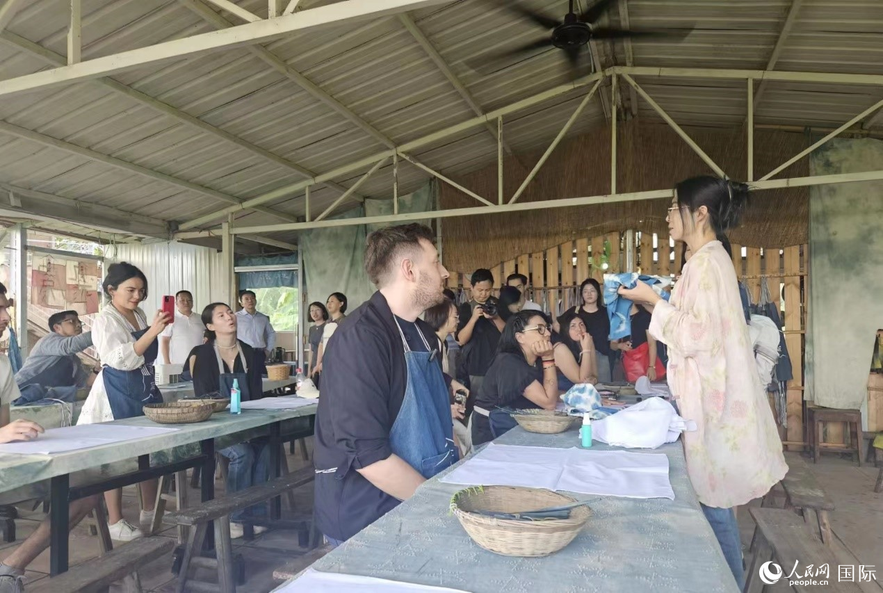 拉美國(guó)家媒體團(tuán)的記者們了解藍(lán)染工藝。人民網(wǎng)記者 王曉霞攝