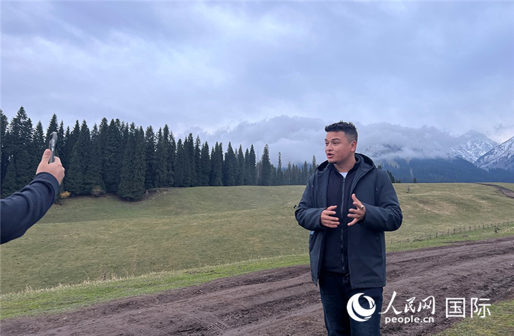 在庫爾德寧，吾買爾江被雪山美景震撼，即興錄制了短視頻作品。人民網記者曾書柔攝