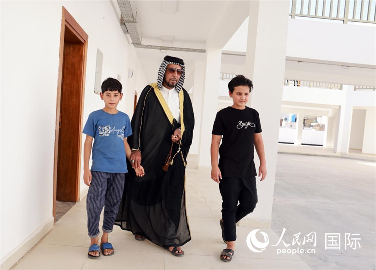 阿卜杜拉帶著孩子們?cè)趨⒂^已完工學(xué)校。人民網(wǎng)記者管克江攝