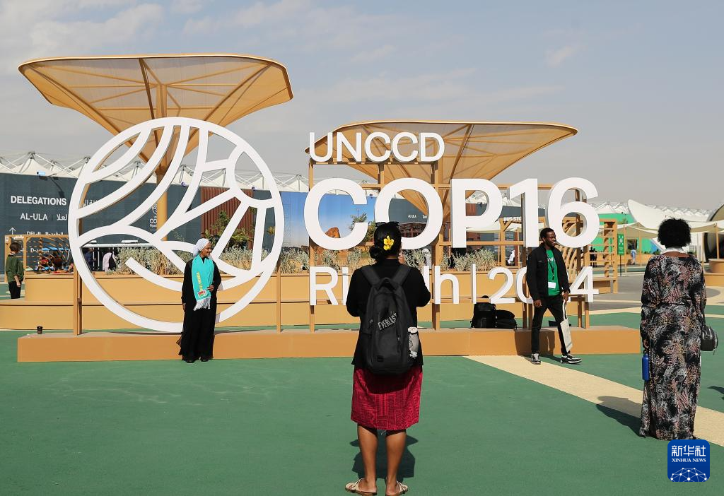 12月3日，在沙特阿拉伯利雅得，參會者在《聯(lián)合國防治荒漠化公約》第十六次締約方大會（COP16）標(biāo)識前拍照。新華社記者 王東震 攝