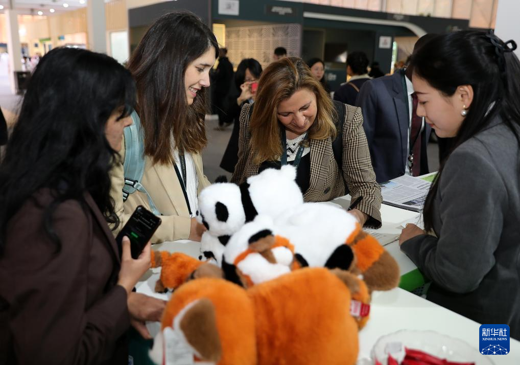 12月2日，在沙特阿拉伯利雅得的聯(lián)合國防治荒漠化公約大會中國館，參會者在留言簿上留言。新華社記者 王東震 攝