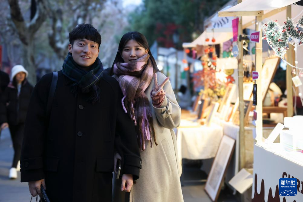 12月25日，韓國(guó)游客周玟佑（左）和金叡恩在上海新天地附近合影。新華社記者 王翔 攝