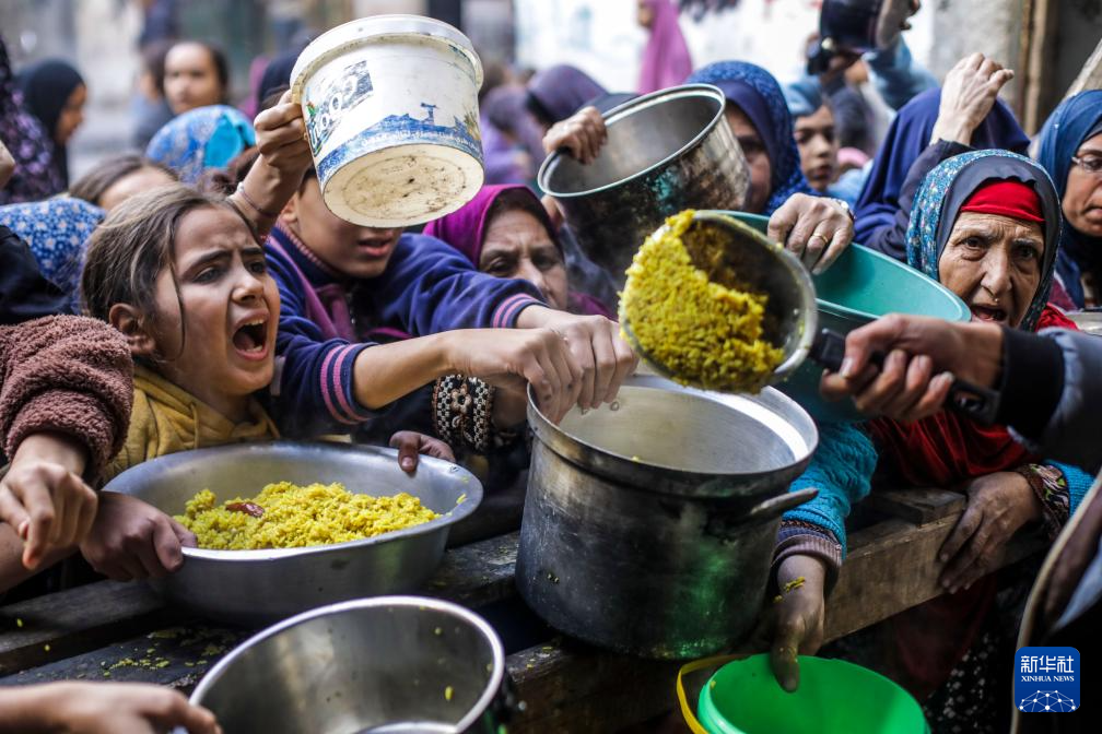 12月27日，巴勒斯坦人在加沙城領(lǐng)取救濟(jì)食物。新華社發(fā)（馬哈茂德·扎基攝）