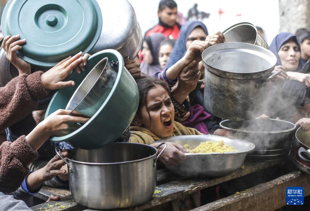 12月27日，巴勒斯坦人在加沙城領(lǐng)取救濟(jì)食物。新華社發(fā)（馬哈茂德·扎基攝）