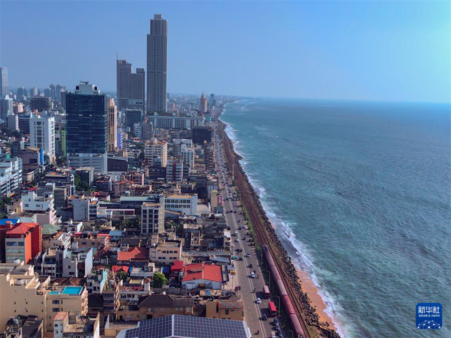 這是12月26日在斯里蘭卡科倫坡拍攝的海邊小火車（手機(jī)照片）?？苽惼碌暮＿呅』疖囀撬估锾m卡著名旅游打卡點(diǎn)。這段火車線路位于斯里蘭卡西海岸，軌道緊貼印度洋，乘客可以全程近距離觀賞海景。新華社記者 陳冬書 攝