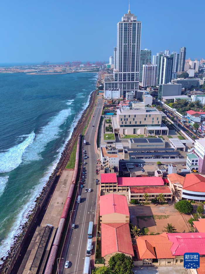 這是12月26日在斯里蘭卡科倫坡拍攝的海邊小火車（手機照片）?？苽惼碌暮＿呅』疖囀撬估锾m卡著名旅游打卡點。這段火車線路位于斯里蘭卡西海岸，軌道緊貼印度洋，乘客可以全程近距離觀賞海景。新華社記者 陳冬書 攝