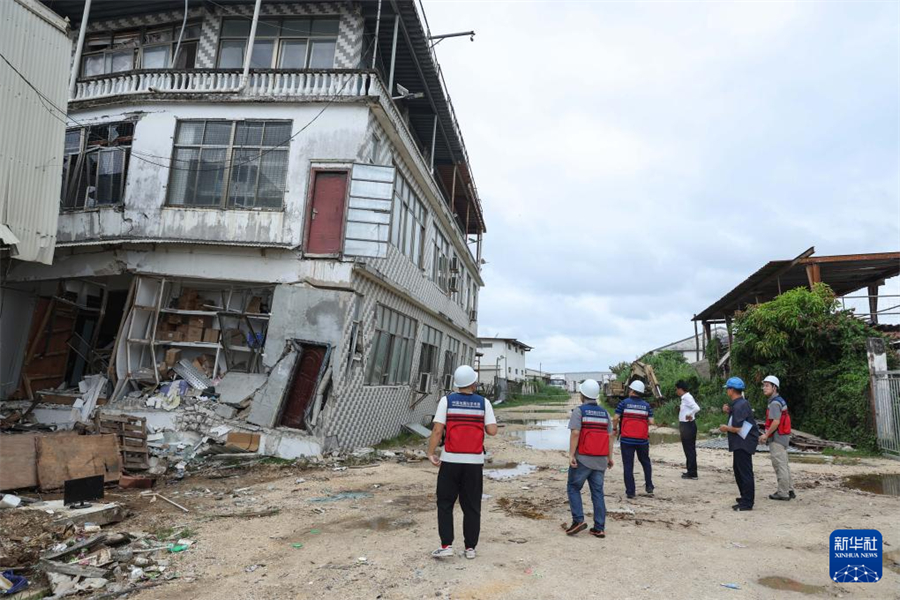 1月1日，在瓦努阿圖維拉港，中國(guó)地震局專家組成員查看房屋受損情況。新華社記者 龍雷 攝