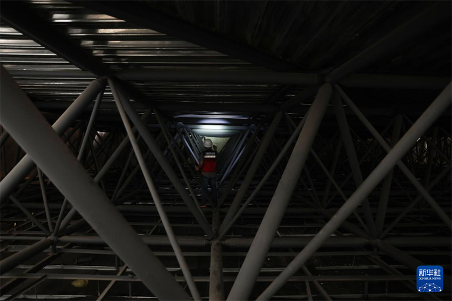 1月1日，在瓦努阿圖維拉港，中國(guó)地震局專家組成員在一棟建筑的結(jié)構(gòu)頂部網(wǎng)架位置查看受損情況。新華社記者 龍雷 攝