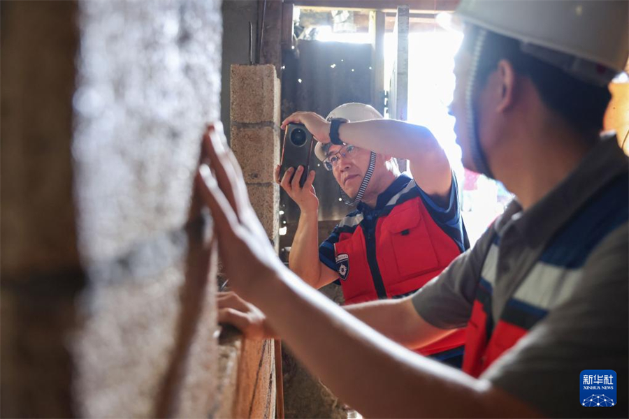 1月1日，在瓦努阿圖維拉港，中國(guó)地震局工程力學(xué)研究所研究員戴君武（左）在一處房屋內(nèi)記錄受損情況。新華社記者 龍雷 攝