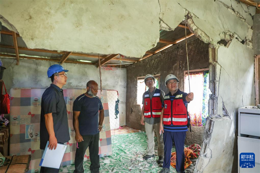 1月1日，在瓦努阿圖維拉港，中國地震局專家組成員在一處房屋內(nèi)查看受損情況。新華社記者 龍雷 攝