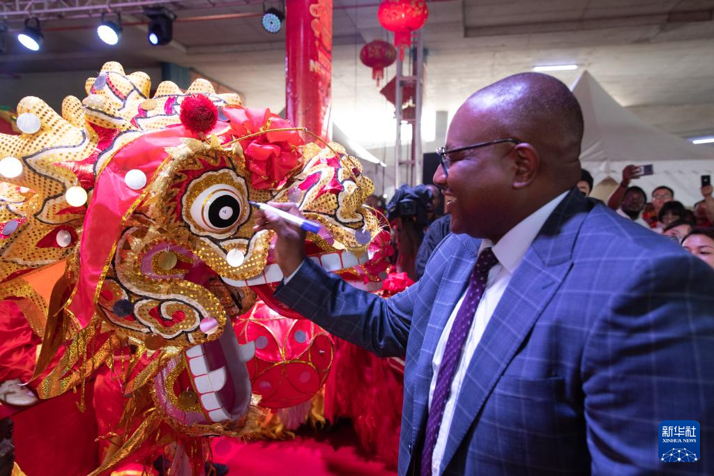 1月19日，贊比亞外交與國(guó)際合作部長(zhǎng)漢貝在首都盧薩卡舉行的春節(jié)廟會(huì)活動(dòng)上為舞龍點(diǎn)睛。新華社記者 彭立軍 攝