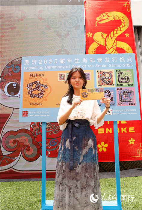 斐濟(jì)華裔女孩張笑若收獲心愛的蛇年生肖郵票首日封。攝影：高鑫