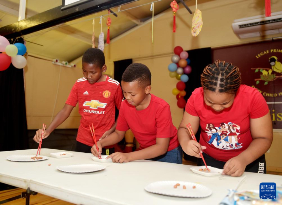 1月29日，在博茨瓦納首都哈博羅內(nèi)的麗海國際小學(xué)，當(dāng)?shù)貙W(xué)生參加筷子夾花生游戲。新華社發(fā)（策基索·特巴洛攝）