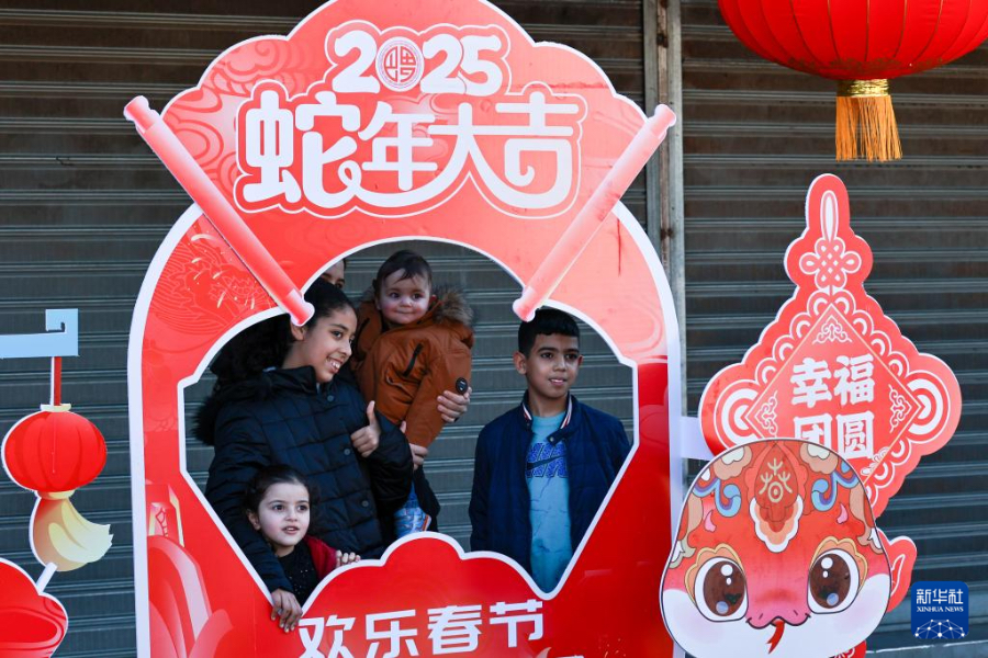 1月18日，在摩洛哥卡薩布蘭卡的“中國(guó)廟會(huì)”活動(dòng)現(xiàn)場(chǎng)，摩洛哥民眾與“歡樂(lè)春節(jié)”宣傳展板合影。新華社記者 霍晶 攝