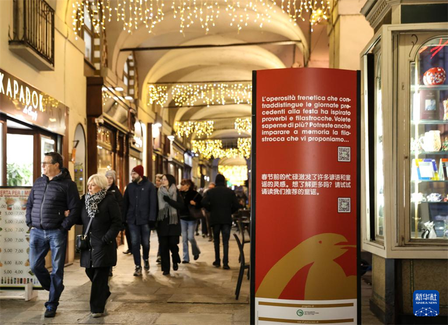 1月31日，在意大利都靈波街，人們經(jīng)過春節(jié)主題展板。新華社記者 李京 攝