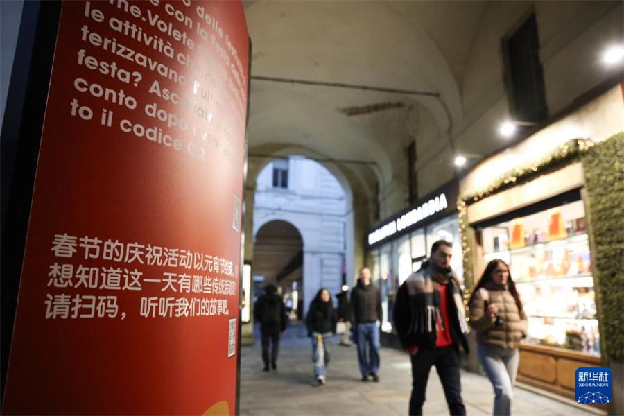 1月31日，在意大利都靈波街，人們經(jīng)過春節(jié)主題展板。新華社記者 李京 攝