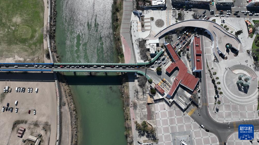 2月16日，在墨西哥科阿韋拉州彼德拉斯內(nèi)格拉斯市，車輛在一座國際橋上行駛，畫面右側(cè)為墨西哥（無人機(jī)照片）。新華社記者 李夢(mèng)馨 攝