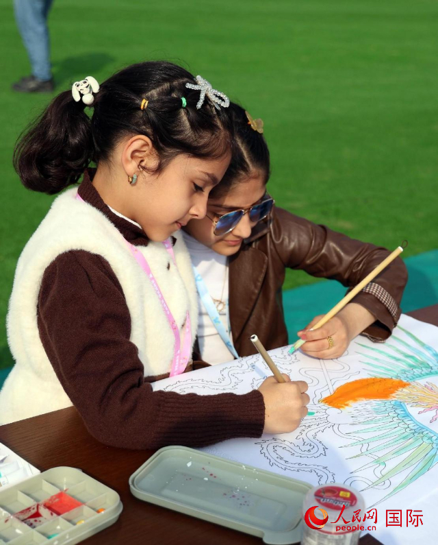兩名女孩在給圖畫上色。人民網(wǎng) 伊納斯·易卜拉欣攝