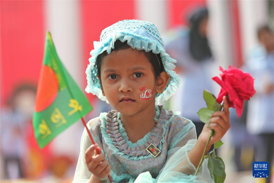 2月21日，在孟加拉國(guó)首都達(dá)卡的語(yǔ)言烈士紀(jì)念碑前，一名兒童參加國(guó)際母語(yǔ)日紀(jì)念活動(dòng)。新華社發(fā)（哈比卜·拉赫曼攝）