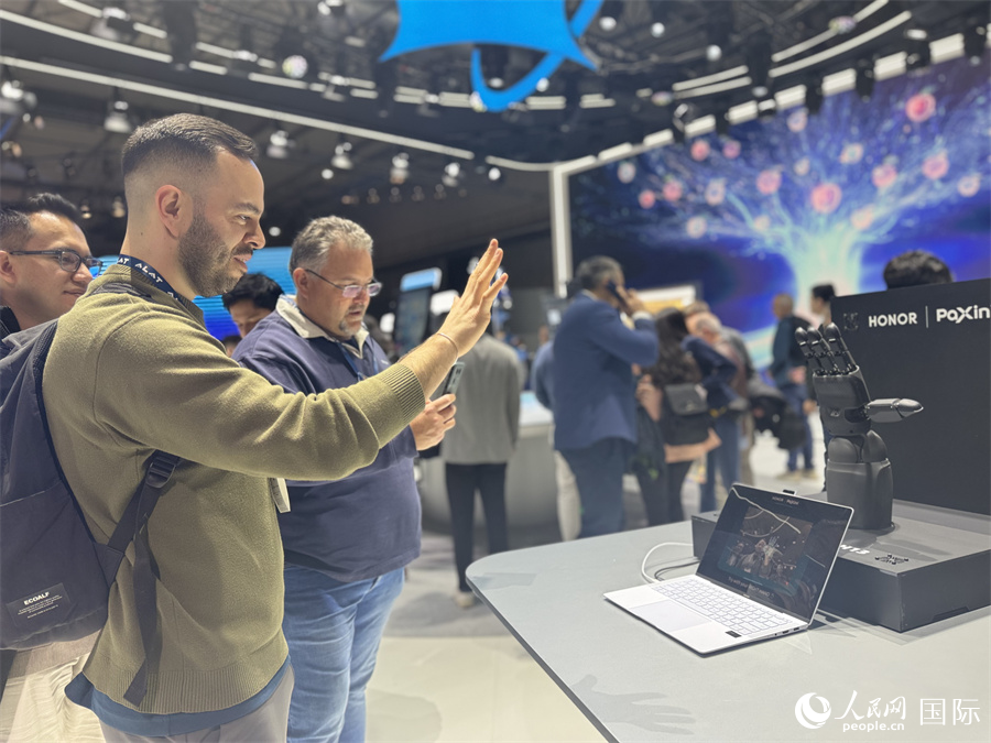 參觀者與榮耀公司合作伙伴帕西尼感知科技的“多維觸覺靈巧手”揮手互動。人民網(wǎng)記者 顏歡攝