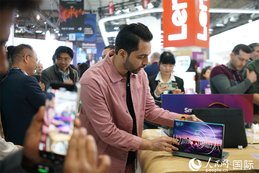 聯(lián)想在2025年世界移動(dòng)通信大會(huì)首發(fā)一款可以將13英寸筆記本屏幕，縱向擴(kuò)展至18.1英寸的外折屏電腦。圖為自媒體人體驗(yàn)外折屏電腦。人民網(wǎng)記者 顏歡攝