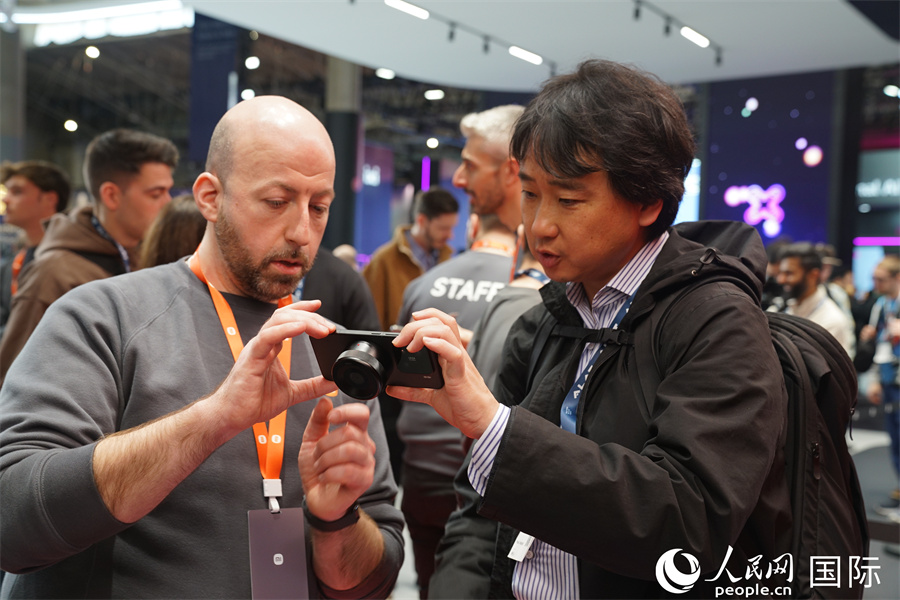小米手機(jī)的磁吸M43鏡頭首亮相世界移動(dòng)通信大會(huì)，手機(jī)變相機(jī)，吸引了諸多參觀者排隊(duì)了解、試用。人民網(wǎng)記者 顏歡攝