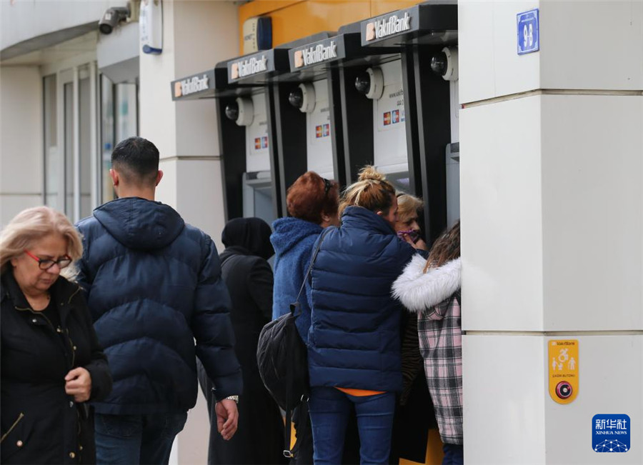 3月6日，人們在土耳其首都安卡拉的一家銀行外使用自動取款機。新華社發(fā)（穆斯塔法·卡亞攝）