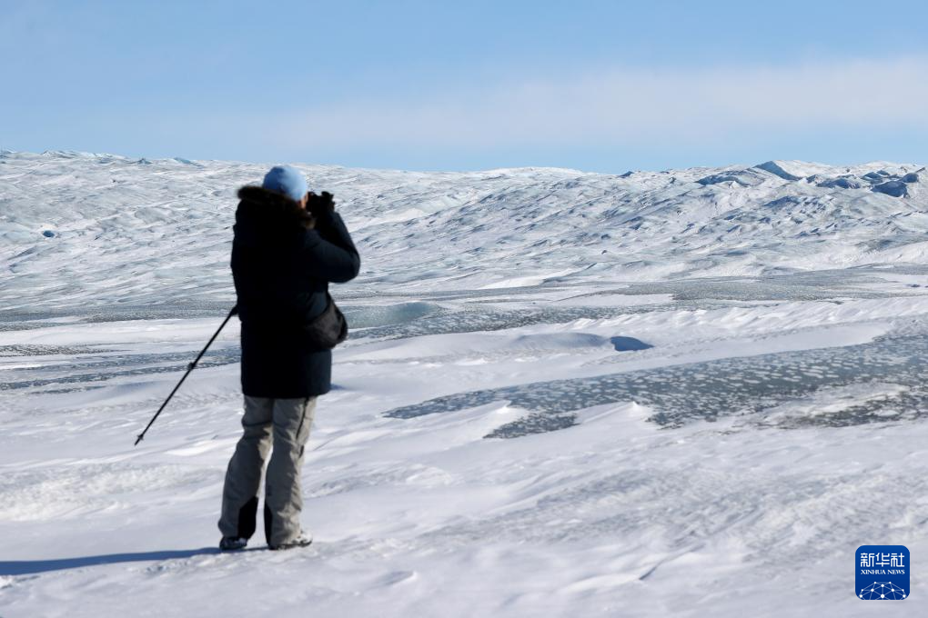 3月21日，在丹麥自治領(lǐng)地格陵蘭島中部的南斯特倫菲尤爾附近，一名男子在拍攝冰蓋。新華社記者 趙丁喆 攝