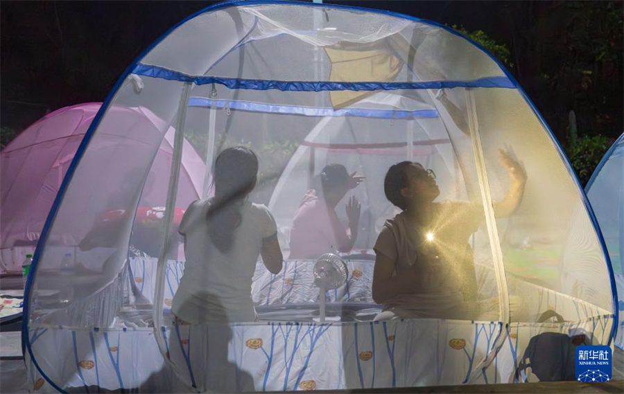 3月31日，在緬甸曼德勒，人們在蚊帳里打蚊蟲。新華社記者 才揚 攝