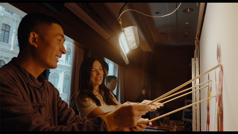 湘潭紙影傳承人吳淵指導英國來賓體驗紙影戲。楊浩鵬攝