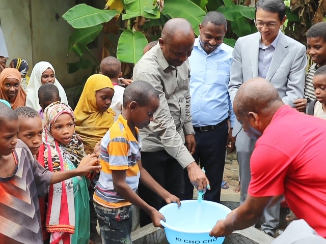 在日前舉行的安全供水工程揭牌儀式上，當(dāng)?shù)匦∨笥言诠┧c(diǎn)接水。 施亮攝