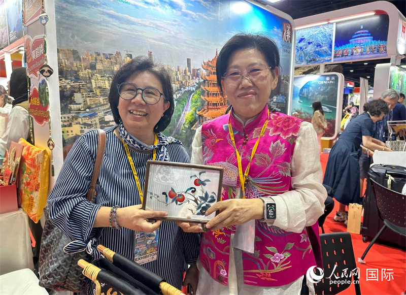 中國“大冶刺繡”傳承人劉小紅（右）參加泰國國際旅游展，向觀眾介紹中國非遺刺繡針法。人民網(wǎng)記者 簡(jiǎn)承淵攝