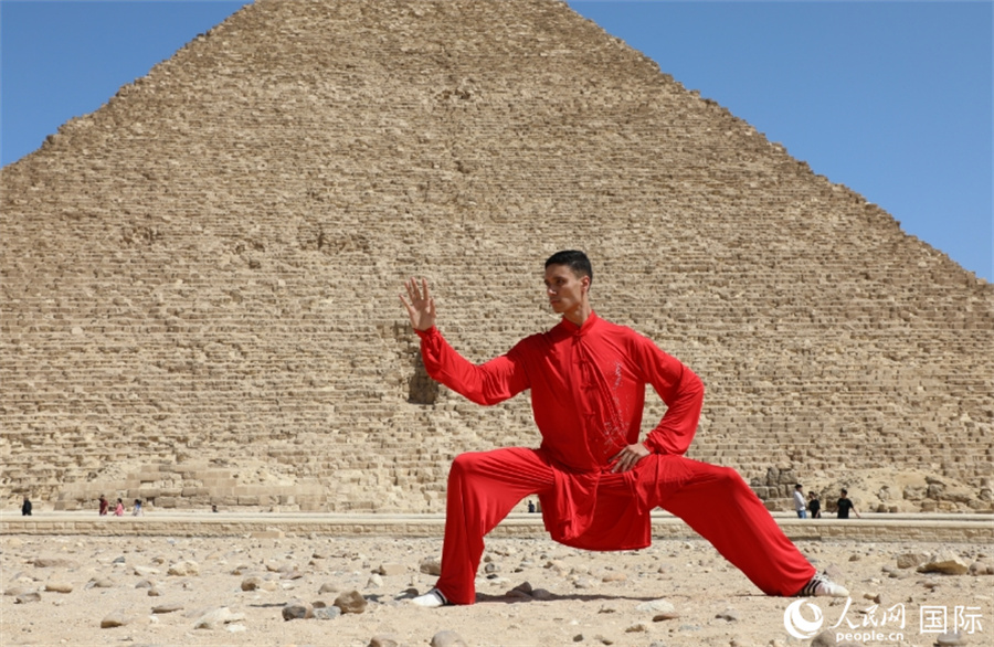 圖為埃及太極拳習(xí)練者在埃及吉薩省金字塔前練習(xí)太極拳動作，在一招一式間用心感悟古老的東方智慧。 人民網(wǎng) 欣德·法蒂·穆罕默德攝