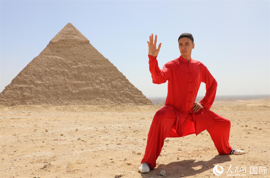 圖為埃及太極拳習(xí)練者在埃及吉薩省金字塔前練習(xí)太極拳動作，在一招一式間用心感悟古老的東方智慧。 人民網(wǎng) 欣德·法蒂·穆罕默德攝