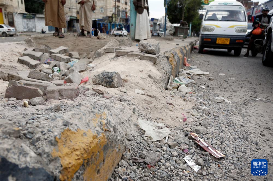 5月5日，在也門首都薩那，車輛駛過空襲中受損的街道。新華社發(fā)（穆罕默德·穆罕默德攝）