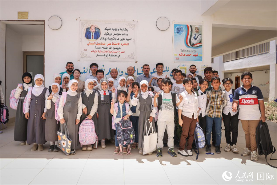 中企項(xiàng)目工作人員與法拉赫學(xué)校師生合影。人民網(wǎng)記者 薛丹攝
