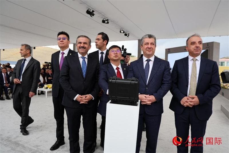 中伊嘉賓摁下按鈕，共同啟動(dòng)水泥廠運(yùn)行。人民網(wǎng)伊納斯·易卜拉欣攝