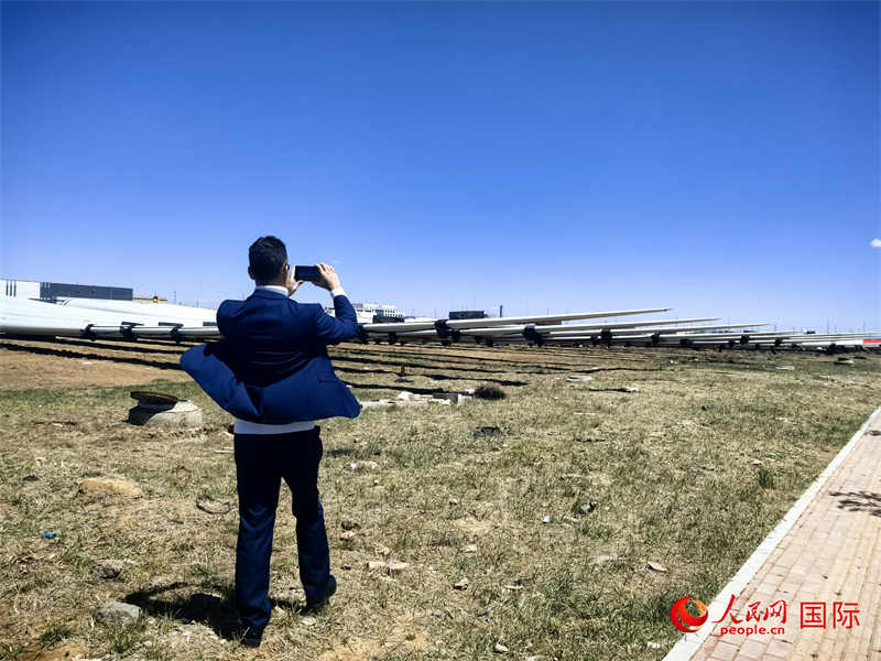 外媒記者拍攝廠房外的風(fēng)力渦輪發(fā)電機(jī)的巨型漿葉。人民網(wǎng) 楊春燕攝