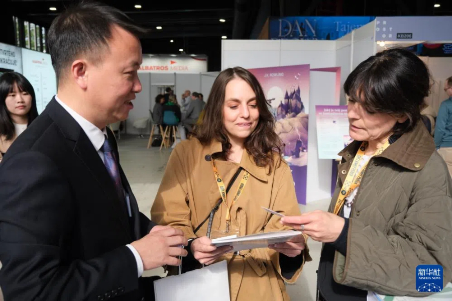 5月15日，在捷克首都布拉格，參觀者在布拉格國(guó)際書(shū)展的中國(guó)展區(qū)與工作人員交流。新華社記者 鄧耀敏 攝