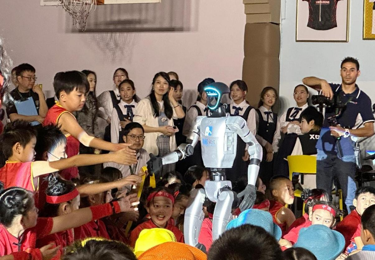 孩子們爭相同機(jī)器人握手。迪拜中國學(xué)校供圖