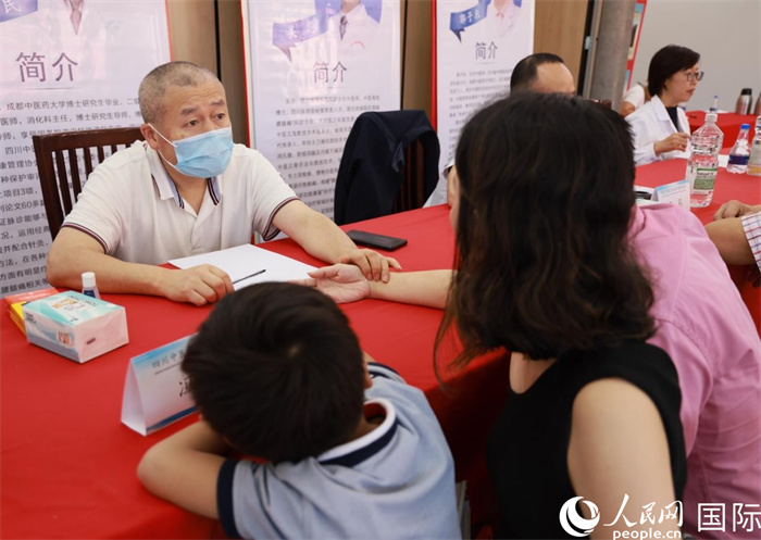 活動(dòng)現(xiàn)場(chǎng)，成都中醫(yī)藥大學(xué)附屬醫(yī)院消化內(nèi)科主任馮培民正在為當(dāng)?shù)貎S胞把脈。人民網(wǎng)記者 宋亦然攝