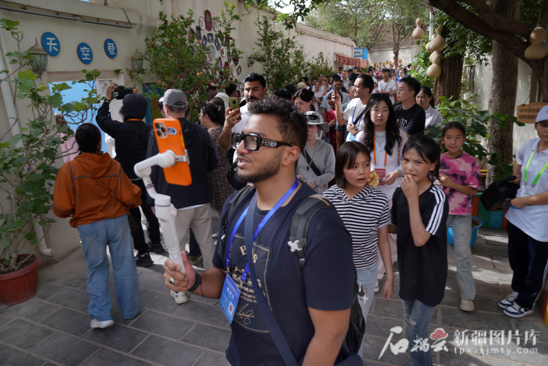 5月24日，在庫車市龜茲小巷，一位嘉賓在記錄他的所見所聞。 
