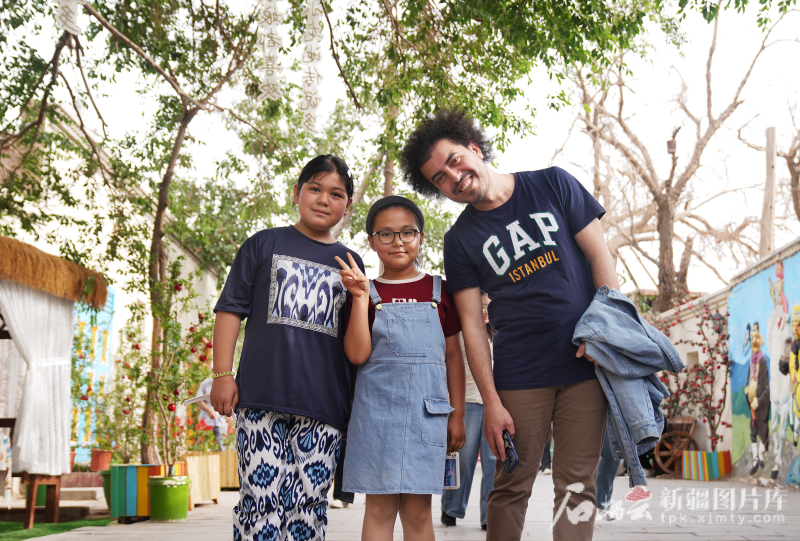 5月24日，在庫車市龜茲小巷，土耳其《自由報》國際新聞主編內(nèi)杰德·布拉克·奧茲尤爾特跟當?shù)貎擅∨笥延押媒涣骱蠛嫌傲裟睢?></p>
<p style=