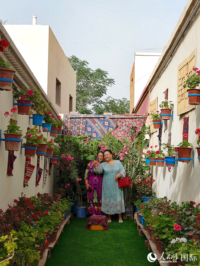 圖為龜茲小巷內(nèi)，當(dāng)?shù)鼐用裨谛蓍e娛樂(lè)。人民網(wǎng)記者 蔣雨師攝