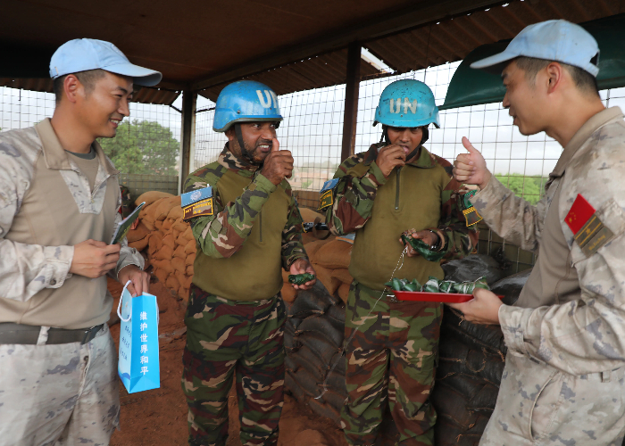 圖為我維和官兵為執(zhí)勤哨兵送去中國粽子。張曉昆攝