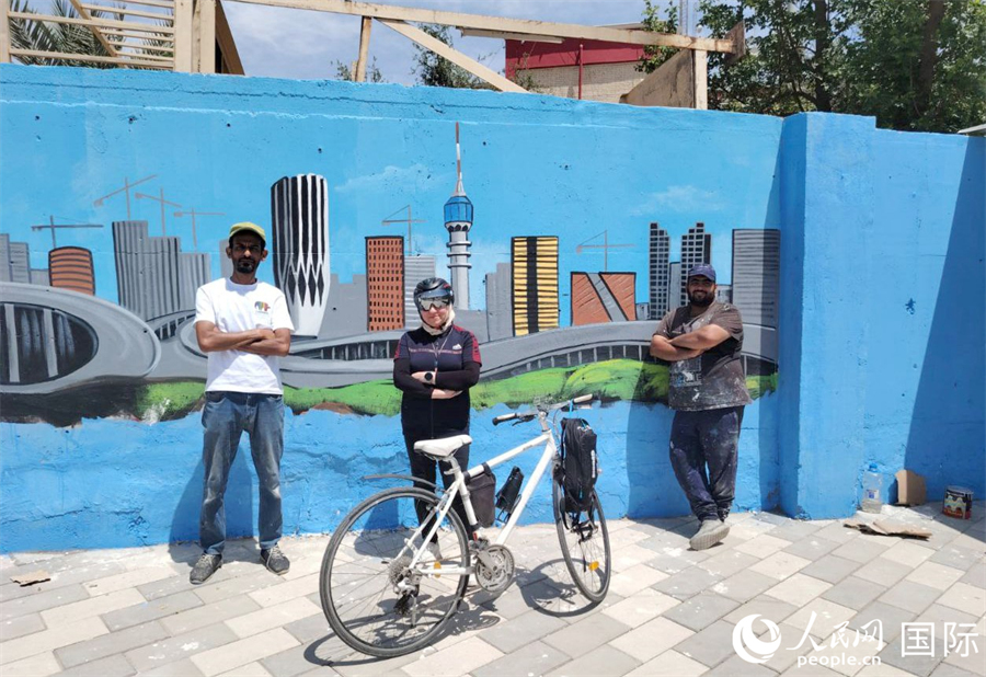 一位街頭騎行者和藝術(shù)家在壁畫墻前合影。人民網(wǎng) 伊納斯·易卜拉欣攝