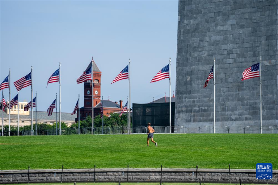 6月23日，在美國首都華盛頓，一名男子在草地上跑步。新華社記者 胡友松 攝