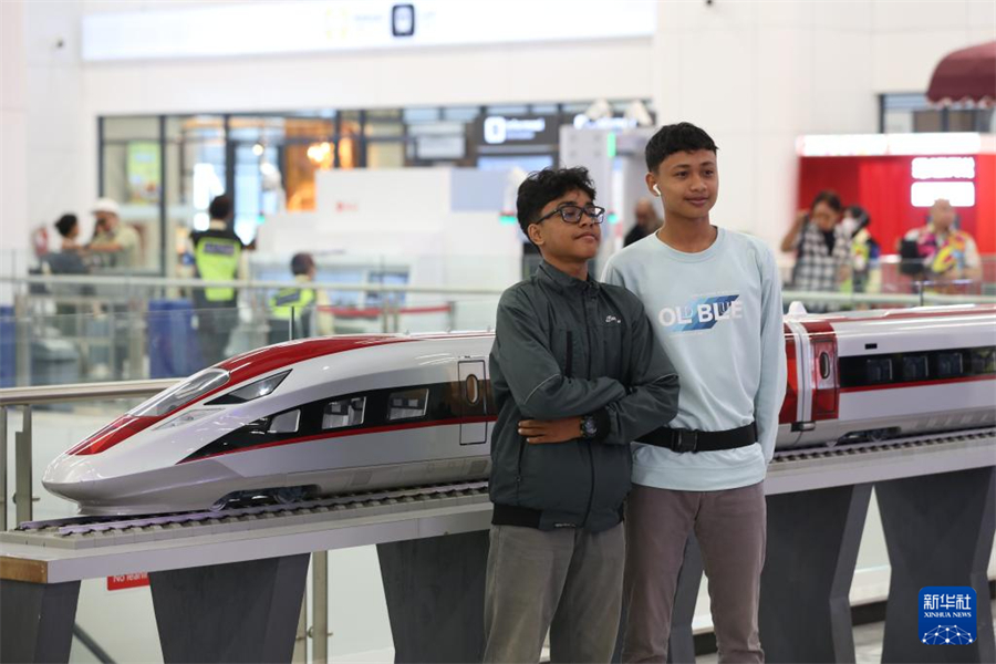6月19日，在印度尼西亞雅加達(dá)，兩名乘客在雅萬高鐵哈利姆站候車大廳與雅萬高鐵高速動(dòng)車組模型合影。新華社記者 岑云鵬 攝